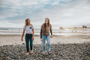 Young and happy women on the beach wearing Nose sunscreen on their faces 