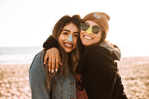 Two bold women wearing reef-safe sunscreen on their nose